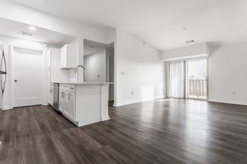 the living room and kitchen in a new home with white walls and wood flooring at Polo Run Apartments, Greenwood